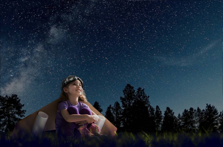 A young girl looks up to the night sky wistfully dreaming of all the wonders above